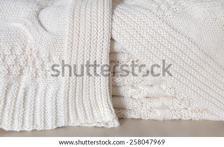 White knitted blanket folded in layers
