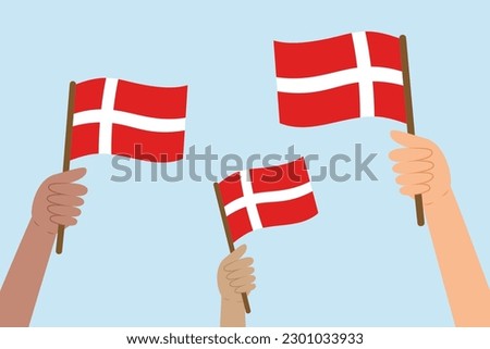 Diverse hands raising flags of Denmark. Vector illustration of Danish flags in flat style on blue background.