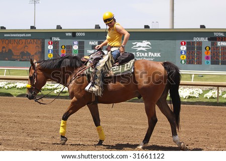 GRAND PRAIRIE,TX - JUNE 6th: A horse trainer is riding back after race at Lone Star Park Horse Race June 6th, 2009 in Grand Prairie, Texas.