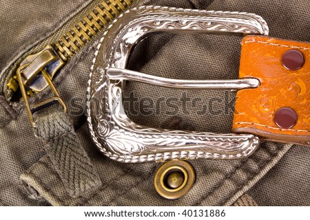 Leather silver belt on camouflage zipper pants.