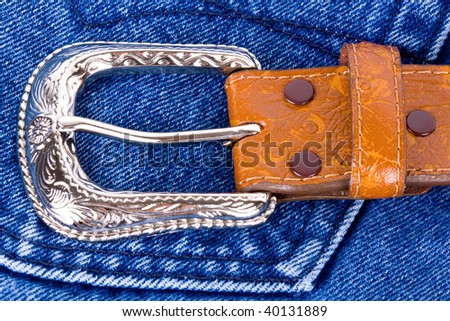 Leather silver belt on cowboy blue jeans.