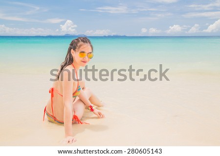 Young women in bikini enjoying on tropical beach.