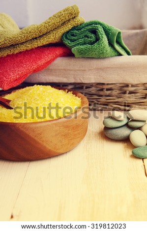 Aromatic salt for Spa therapies in a wooden bowl, with a towel and sea stones. Alternative medicine. Care of a body.
