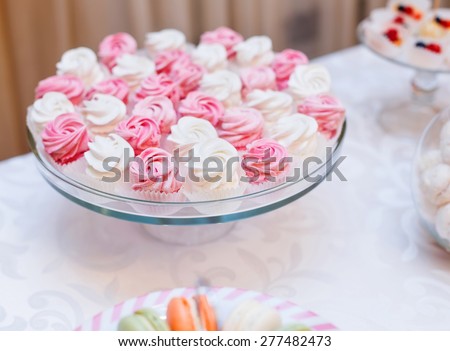 Dessert for holiday. Pink and white meringues, tart, cupcakes, muffins, macaroons, cakes and sweetness. Wedding dessert.
