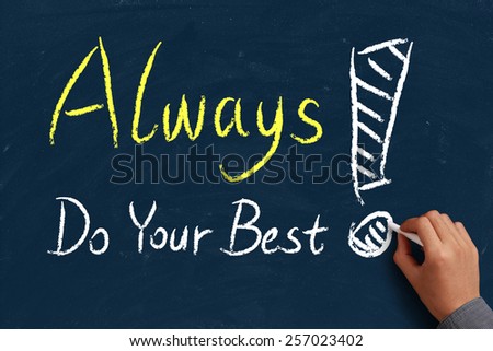 Always do your best on blue chalkboard with the hand of businessman.