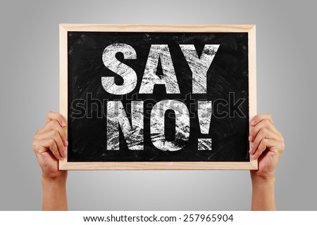 Say No blackboard is holden by hands with gray background.