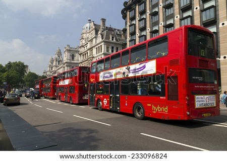 London, United Kingdom September 4, 2013: 4 Double decker London buses waiting in the traffic lights next to Big Ben. Closest one is a Hybrid model.