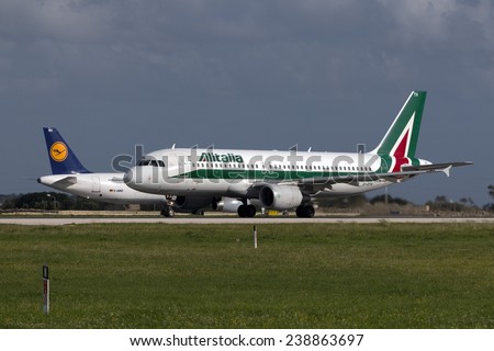 Luqa, Malta December 17, 2014: Alitalia Airbus A320-216 starts it take off run from runway 31, while a Lufhansa A321 waits its turn in the background.