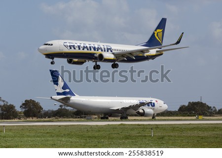 Luqa, Malta February 25, 2015: Ryanair Boeing 737-8AS landing runway 31 with MNG Airlines Cargo Airbus A300B4-605R waiting for take off on the Alpha loop.