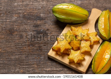 organic carambola asian fruit, star fruit, grown on organic farm in a wicker basket on a rustic wooden table top view with space for writing Сток-фото © 