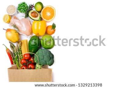 Healthy food background. Healthy food in paper bag meat, fruits, vegetables and pasta on white background. Shopping food in supermarket, dieting concept. Long format with copy space