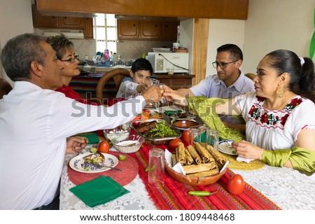 A Mexican family toasting and celebrating at a mexican party at home