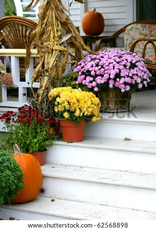 Traditional brick colonial dressed up for fall with colorful mums and harvest gourds