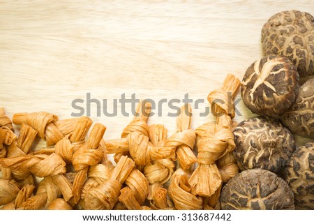 Dried shiitake mushrooms and bean curd on wooden background with copy space ; Frame for food preservation background