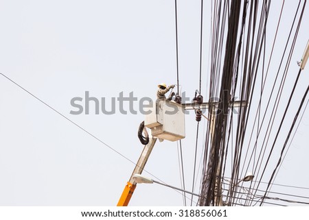 Electrician working repairing the power line on hydraulic platform