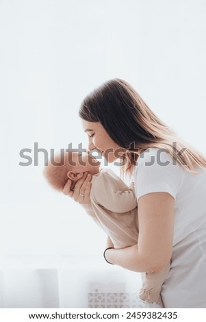Similar – Image, Stock Photo Young mother holding her little baby against white wall in sunny day