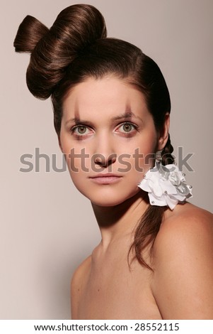 Portrait of pretty young woman with creative coiffure and make-up