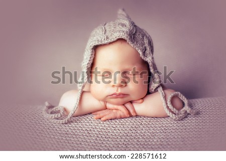 Newborn in hat on the blankets folded handles