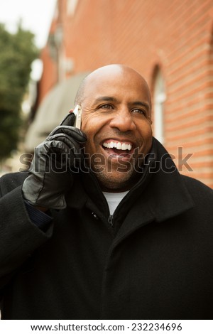Mature man on the phone. Cheerful African man in talking on the mobile phone and smiling.