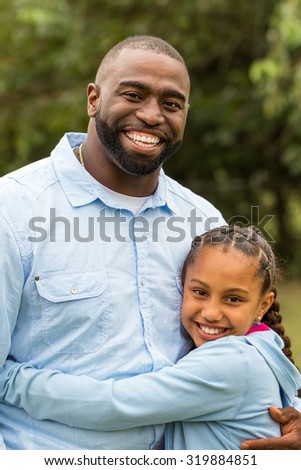 African American Father hugging his daughter.