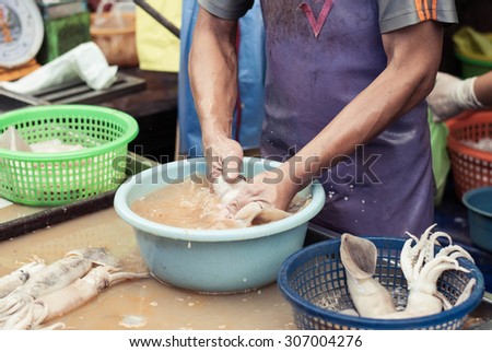 Shopkeeper cleaning squids