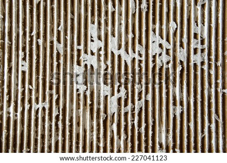 Corrugated cardboard background is cut and painted with white paint in some places