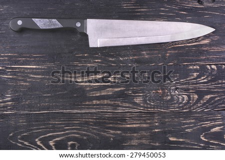 Big steel kitchen knife on a dark wooden background