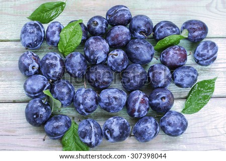 Blue plums on wooden background. top view