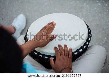 The guy's hands play the drum, the African beats the rhythms of the music on the djemba, the ethnic music in the streets is proud, the street musician from Africa, the black hands. High quality photo Сток-фото © 