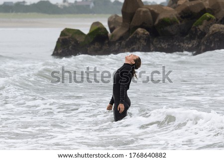 Similar – Image, Stock Photo Surfer woman with wetsuit and surfboard looking at the sea
