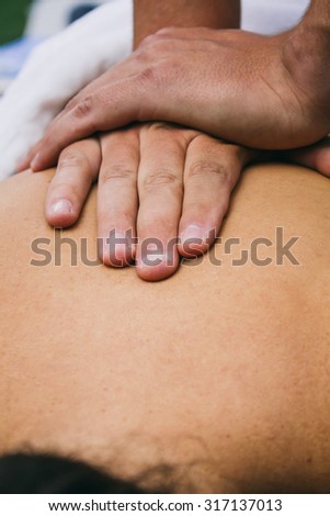 Hands of a physiotherapist on the back of a patient
