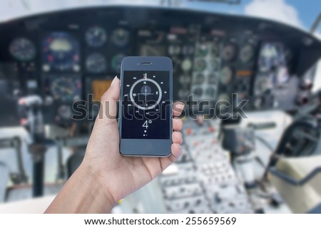Orientation Concept a Hand Holding a Compass on smart phone in control room helicopter