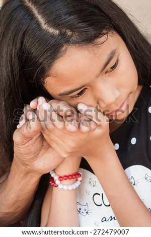 asian kids little girl  hand touches and holds an old man wrinkled hands at face of her