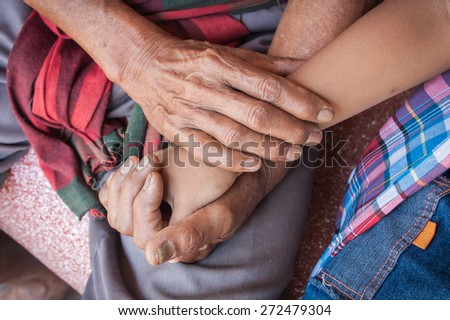 kids little boy hand touches and holds an old man wrinkled hands.