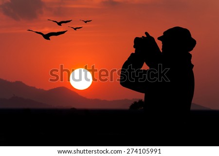 silhouette of beautiful women photographing eagle bird flying on the sky at sunrise range