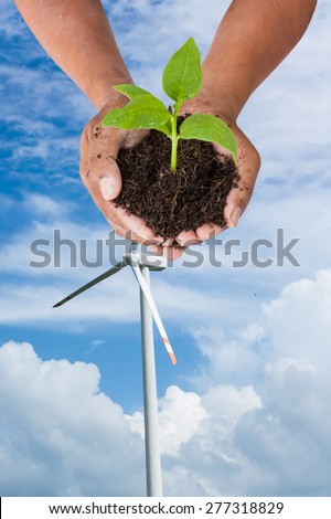 environment concept, save the world - man hand holding green tree  on wind turbine  background