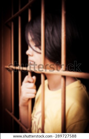 vintage of blurry of asian girl Hand in jail looking out the window