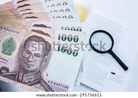 Thai money in black wallet on marketing book background