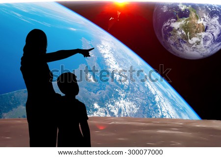 silhouette of mother and son point look at to the earth, the backdrop of the planet earth. Elements of this image furnished by NASA.