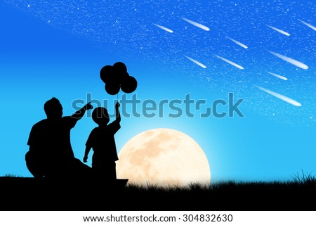 Silhouette of father and son see star on the sky