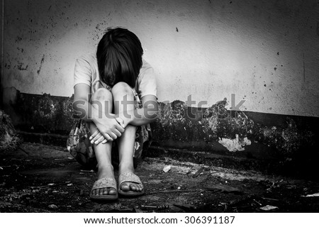 asian girl sad alone sitting near old wall cement,black and white tone