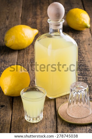 Lemon liquor Limoncello on wooden table. Italian alcoholic beverage.