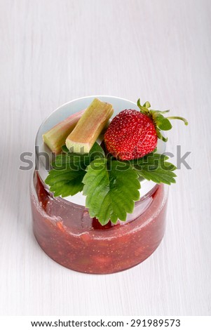Cooking homemade strawberries jam: Strawberries and rhubarb jam in a glass jar