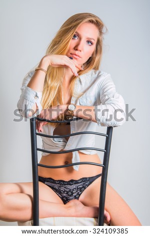 Young woman sitting on chair, fashion self confident pose, beauty concept