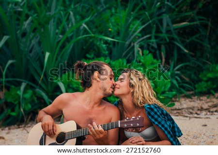 The guy sings the song to the woman on a beach