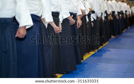 People in kimono and hakama standing in a long line on martial arts training seminar. Selective focus