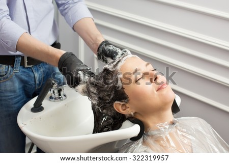 Beautiful woman washing hair after hair coloring in studio