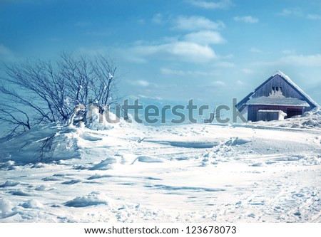 The old wooden roof covered with snow and blue sky