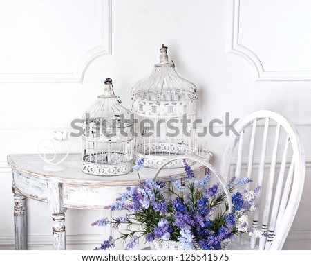 vintage chair and table with flower in front and cages