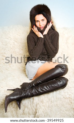 beautiful girl in black fur hat and leather boots